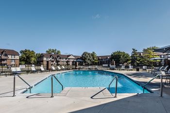 our apartments have a resort style pool with chairs around it at Bavarian Village Apartments, Indianapolis, IN